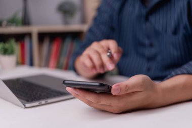Businessman using smartphone for online communication and task planning at workspace. Digital business and modern technology.Remote office, mobile workflow.