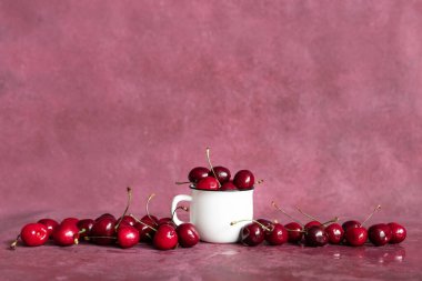 Beyaz bardakta taze yaz meyveleri. Kiraz arkaplanı. Yaz meyveleri ve gıda konsepti. Kopyalama uzayıyla.
