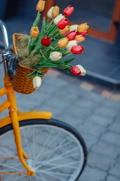 Bright orange bike with basket of flowers