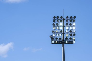 Stadyum izole mavi gökyüzü arka plan üzerinde bir projektör