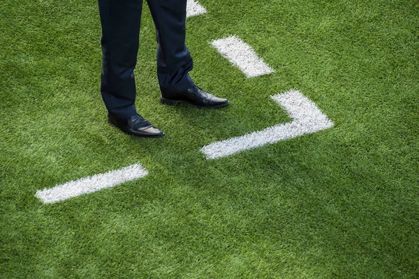 Coach standing next to chalk line on soccer field