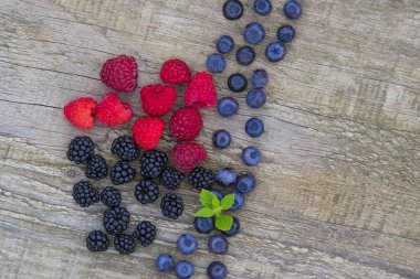 böğürtlen, ahududu, yaban mersini eski ahşap masa arka plan üzerinde karışımı. kopya alanı ile üstten görünüm