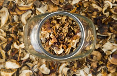 Eski ahşap arka plan üzerinde kurutulmuş kurutulmuş mantar dilimlenmiş bir kavanoza çörek