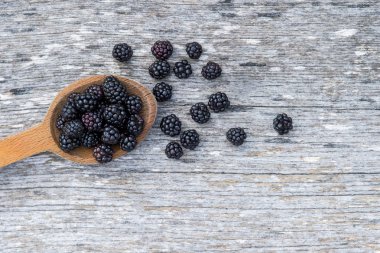 Eski ahşap zemin üzerine tahta kaşık olgun böğürtlen