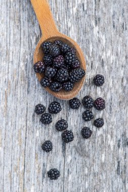 Eski ahşap zemin üzerine tahta kaşık olgun böğürtlen