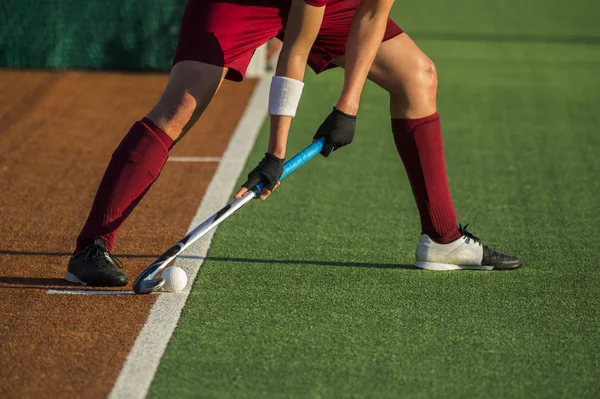 Jogador de hóquei em campo treinando e praticando o esporte na grama