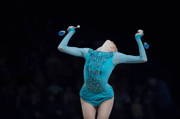 woman in gymnast suit show athletic skill on black background