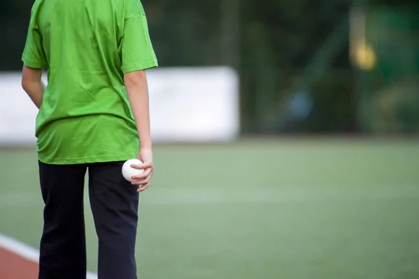 Field hockey white ball in the child\'s hand