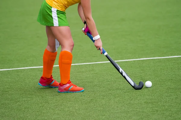 Young hockey player woman with ball in attack playing field hockey game