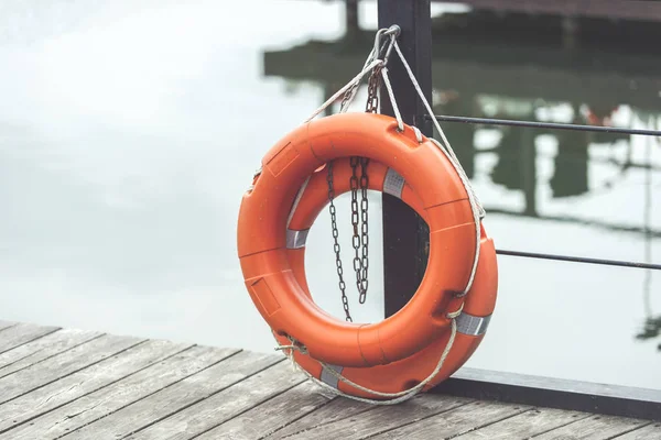 Arka Planda Göl Ile Bir Turuncu Lifebuoy Yüzük — Stok fotoğraf
