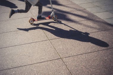 küçük çocuk sürme scooter sokak üzerinde düşük bölümü