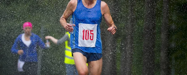 奔跑的人在雨下跑城市马拉松 — 图库照片
