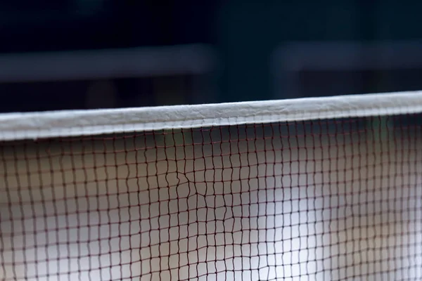 Badminton net indoor on badminton court, closeup view of badminton net with blurry background