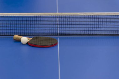 mavi bir tabloda Masa Tenisi yalanlarla net arka plan üzerinde beyaz topu