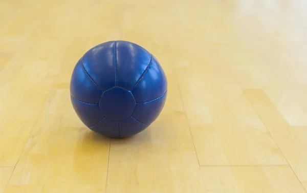 Blue medicine weight ball on wooden floor. Crossfit ball