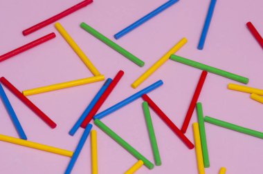 Pembe bir arka plan karşı renkli ahşap sopa