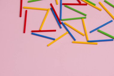 Pembe bir arka plan karşı renkli ahşap sopa