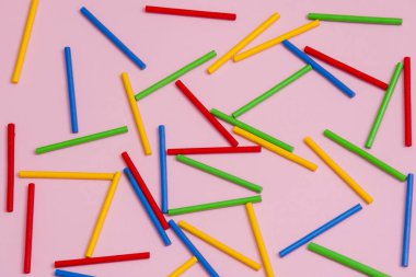 Pembe bir arka plan karşı renkli ahşap sopa