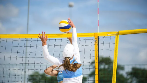 Volleyball beach player is a female athlete volleyball player playing beach volleyball during sunset or sunrise