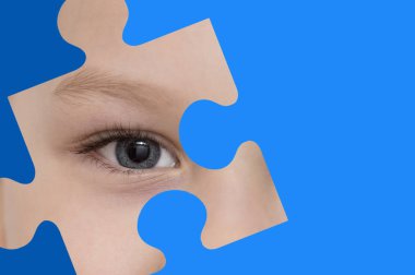 Kid spies through a blue puzzle. Symbol of autism awareness clipart