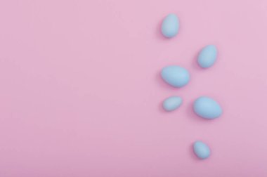 Pembe bir arka plan üzerinde yayılmış Paskalya yumurtaları