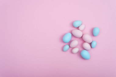 Pembe bir arka plan üzerinde yayılmış Paskalya yumurtaları