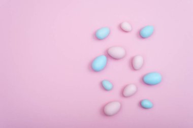 Pembe bir arka plan üzerinde yayılmış Paskalya yumurtaları