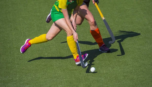 Dos mujeres luchan por el control de la pelota durante el juego de hockey sobre hierba — Foto de Stock