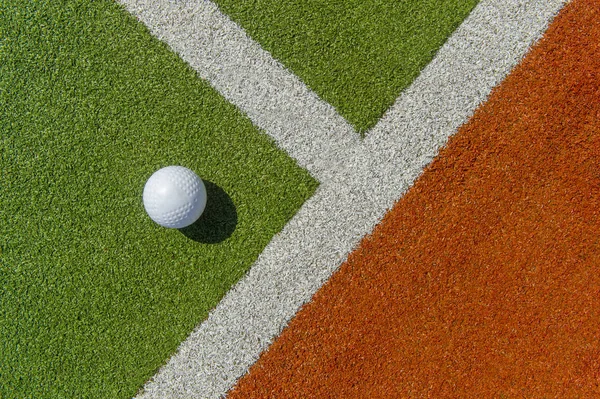 White dimple hockey ball on astro turf