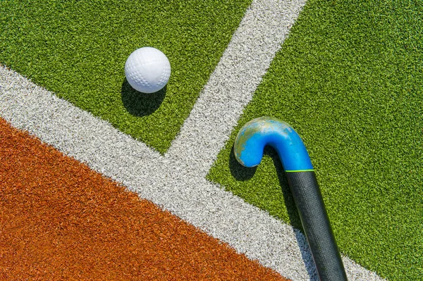 Pozemní hokejové hole a koule na hnědé a zelené trávě — Stock fotografie