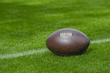 Amerikan futbolu, yeşil çim alan arka plan üzerinde rugby topu