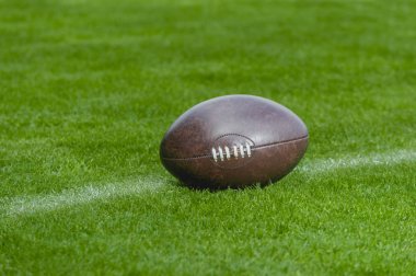 Amerikan futbolu, yeşil çim alan arka plan üzerinde rugby topu