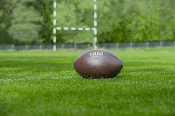 Fútbol americano, pelota de rugby en el fondo del campo de hierba verde — Foto de Stock