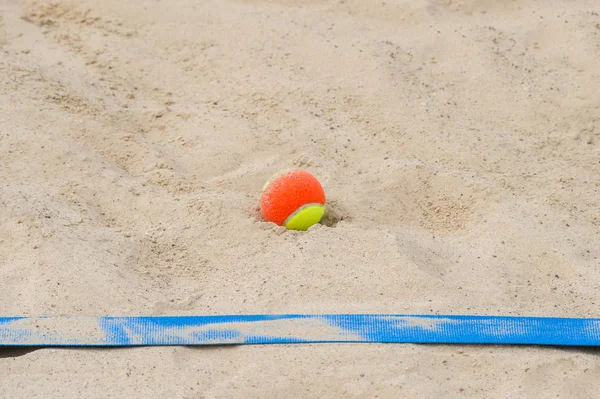 Pelota de tenis en la arena en la playa de cerca — Foto de Stock