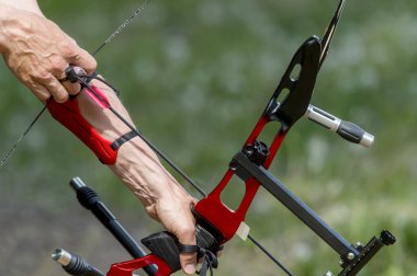 Archer, spor yay dizesini çeker, hedefine nişan alarak