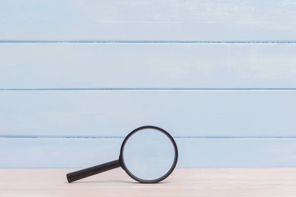 Magnifying glass on a pink wooden table