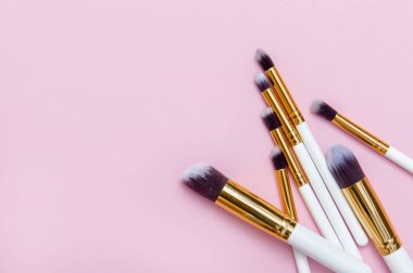 Makyaj fırçaları pembe arka plan ayarlayın. Üstten bakış noktası, düz yatıyordu. Üstten görünüm