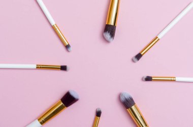 Makyaj fırçaları pembe arka plan ayarlayın. Üstten bakış noktası, düz yatıyordu. Üstten görünüm