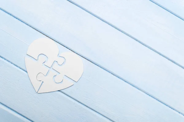 White heart made of symbolic autism puzzle pieces