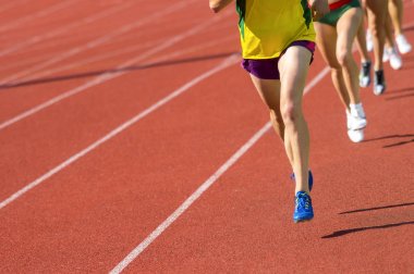 Pist alanında çalışan atletizm insanları. Güneşli gün