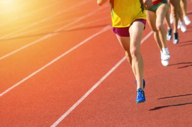 Pist alanında çalışan atletizm insanları. Güneşli gün