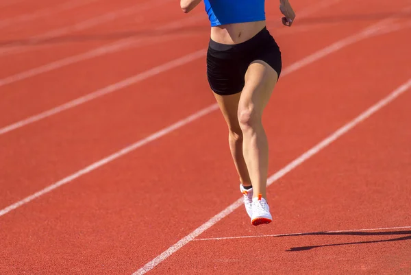 Jovem mulher esportiva correndo no dia ensolarado — Fotografia de Stock