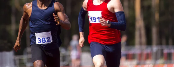 Manliga idrottare tävlar. Två män i träningskläder springa på flykt — Stockfoto