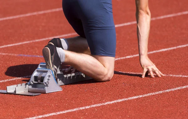 Runners preparing for race at starting blocks — Stock Photo, Image