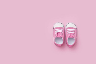 Sevimli pembe kız bebek spor ayakkabıları pembe arka plan üzerinde yakın