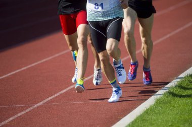 Pist alanında çalışan atletizm insanları. Güneşli gün