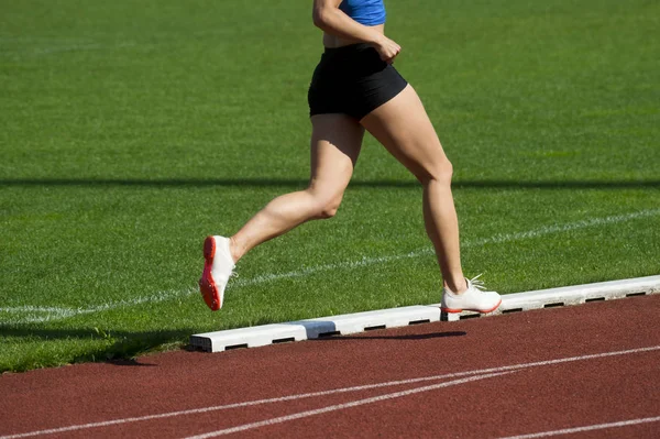 Atletismo mulher correndo no campo de atletismo — Fotografia de Stock
