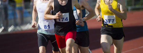 Friidrott människor som kör på spåret fältet. Solig dag — Stockfoto