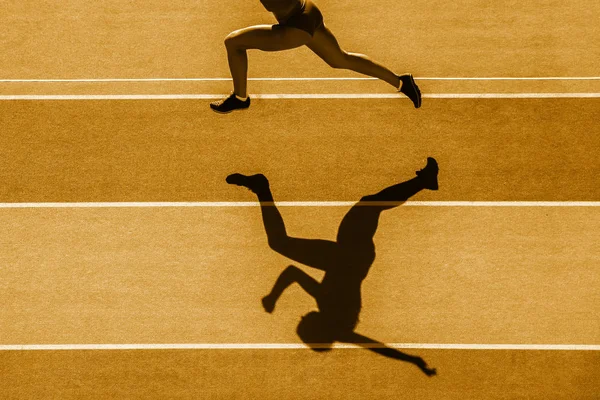 one caucasian woman runner jogger running in silhouette  on stadium background. Yellow color filter.