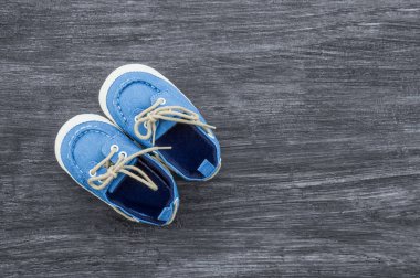 Metin için alan ile ahşap bir arka plan üzerinde bebek ayakkabıları. Üstte görüntü